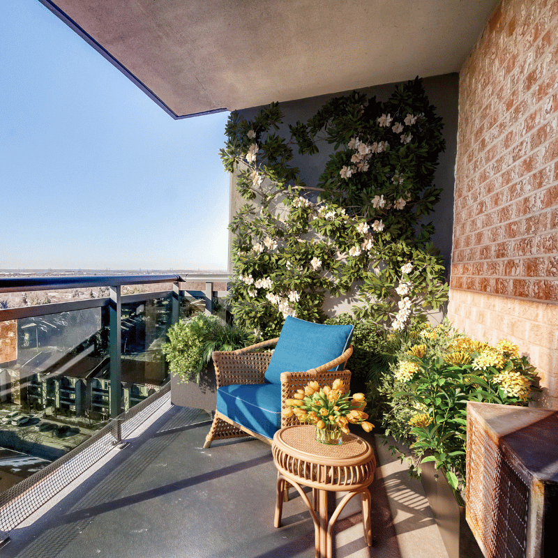 Staged balcony with greenery and an armchair.